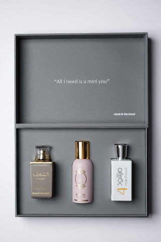 Three perfume bottles on a gray shelf with a motivational quote above by Atyab Al Marshoud.