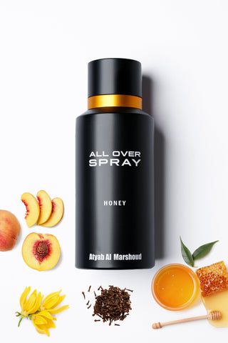 Black spray bottle labeled 'All Over Spray Honey' with peach slices, honeycomb, and flowers on a white background by Atyab Al Marshoud.