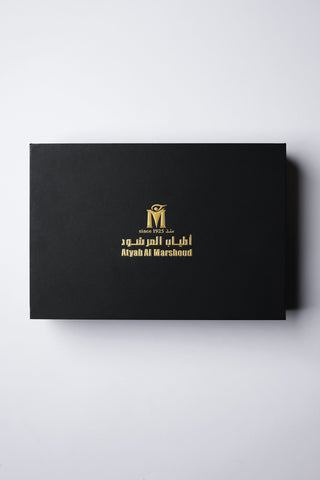 Black box with gold logo and text on a white background by Atyab Al Marshoud.