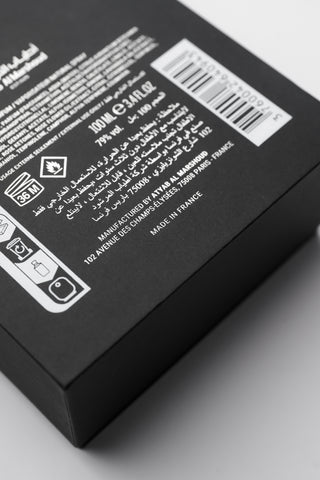 Black product packaging with text and barcodes on a light gray background