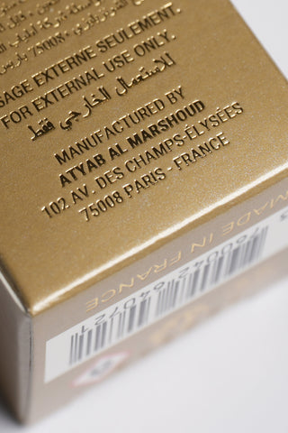 Close-up of a gold product packaging with text and a barcode on a white background by Atyab Al Marshoud.