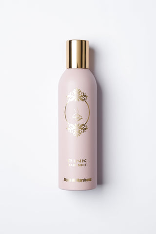 Pink body mist bottle with gold cap on a white background by Atyab Al Marshoud.