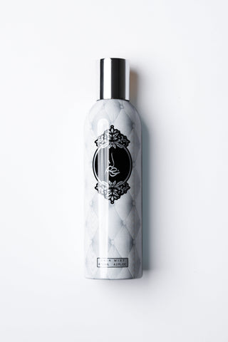 Marble-textured bottle with a silver cap on a white background by Atyab Al Marshoud.