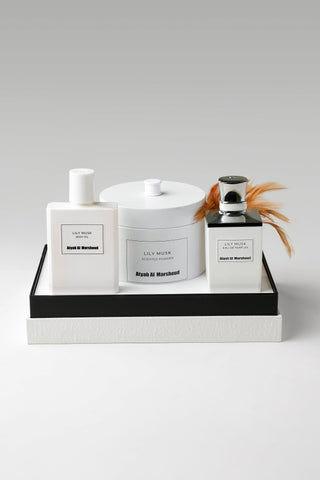 Three white bottles with black labels on a gray surface by Atyab Al Marshoud.