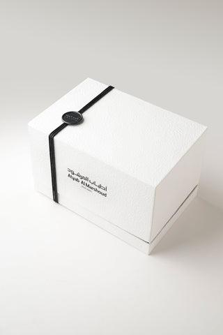 White box with a black strap and text on a white background by Atyab Al Marshoud.