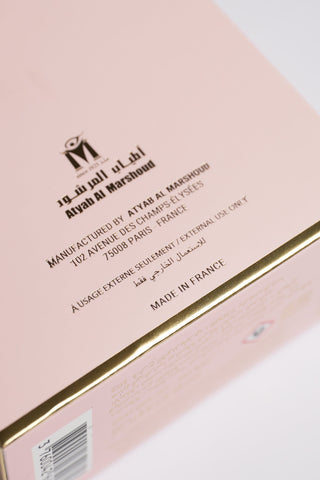 Close-up of a pink cosmetic box with branding and text on a white background by Atyab Al Marshoud.