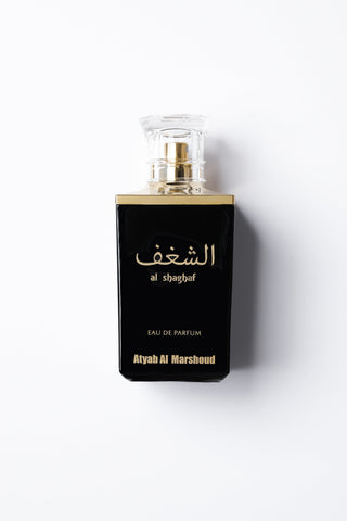 Perfume bottle with black packaging and gold accents on a white background by Atyab Al Marshoud.