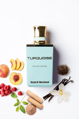 Turquoise perfume bottle with gold cap on a white background, surrounded by fruits and flowers by Atyab Al Marshoud.