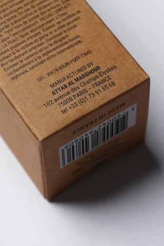 Brown cardboard box with text and barcode on a white background by Atyab Al Marshoud.